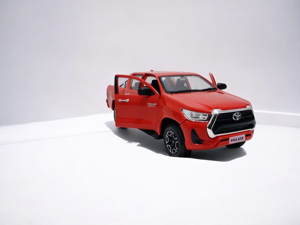 Réplica a escala 1:27 de Toyota Hilux roja por Maisto, modelo de colección con detalles de carrocería, ideal para coleccionistas chilenos
